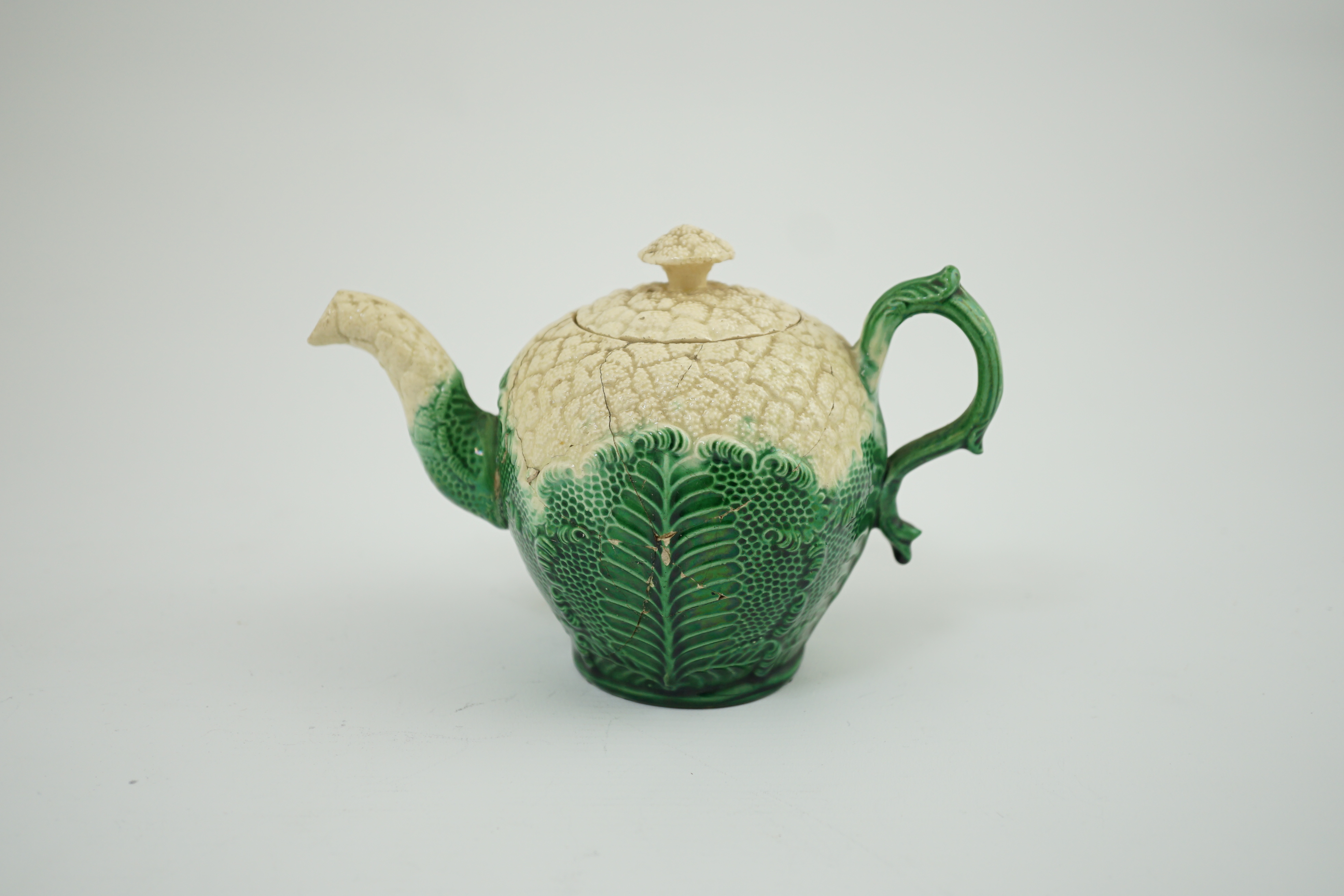 A Staffordshire cauliflower shaped creamware teapot and cover, c.1770, 10. 5 cm high. Condition - broken and repaired